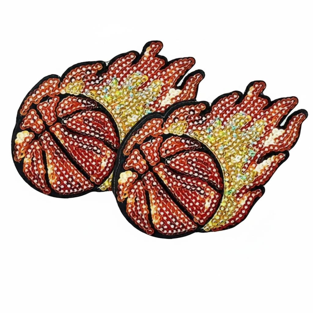 Two embroidered patches shaped like basketballs with flame-like tails, decorated with red, orange, yellow, and white rhinestones on a white background.