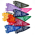 Six colorful embroidered 'GAME DAY' pennant patches in different colors (green, pink, purple, red, orange, blue) arranged on a white background.