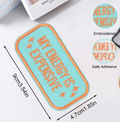 A rectangular adhesive patch with rounded corners, featuring a light blue center and orange border with the text 'MY ENERGY IS EXPENSIVE' in orange. The image includes dimension markings of 8cm by 4.