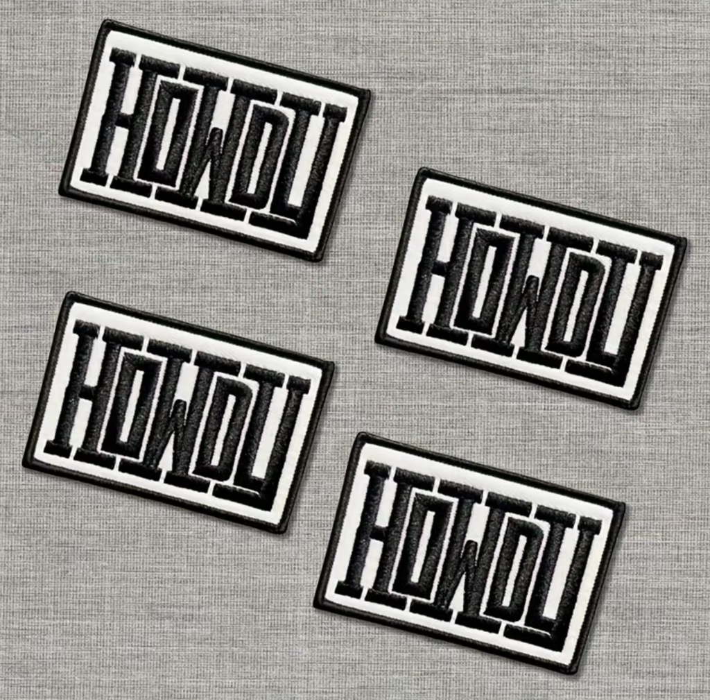Four rectangular embroidered patches with the word 'HOWOU' in black outlined lettering on a white background, arranged on a gray textured surface.