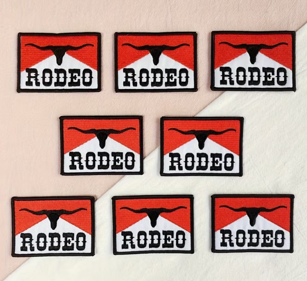 Seven rectangular RODEO patches arranged on a light surface, each with a red and black mountain-like logo above the word 'RODEO' in white.