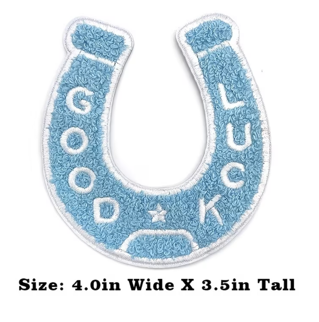 A horseshoe-shaped embroidered patch with the words 'GOOD LUCK' in white letters on a light blue background, shown on a white card with size text below.